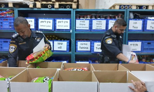 Des policiers emballent des colis alimentaires